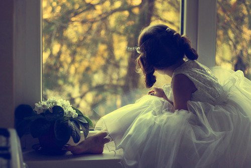 nena vestida de princesa mira por la ventana